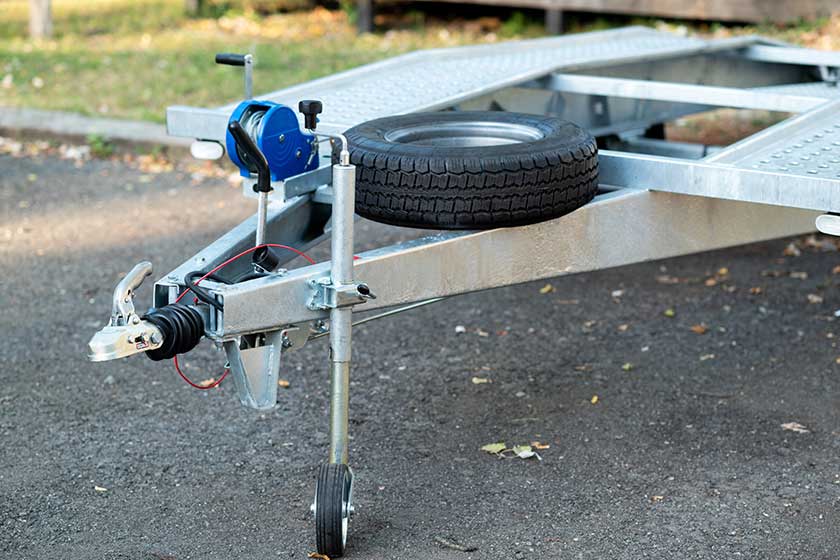 A close-up of a metal trailer hitch with a mounted spare